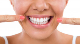 Frau präsentiert ihre weißen Zähne